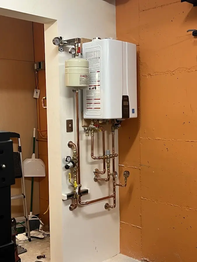 Plumbing technician inspecting water heater connections in Golden Gate